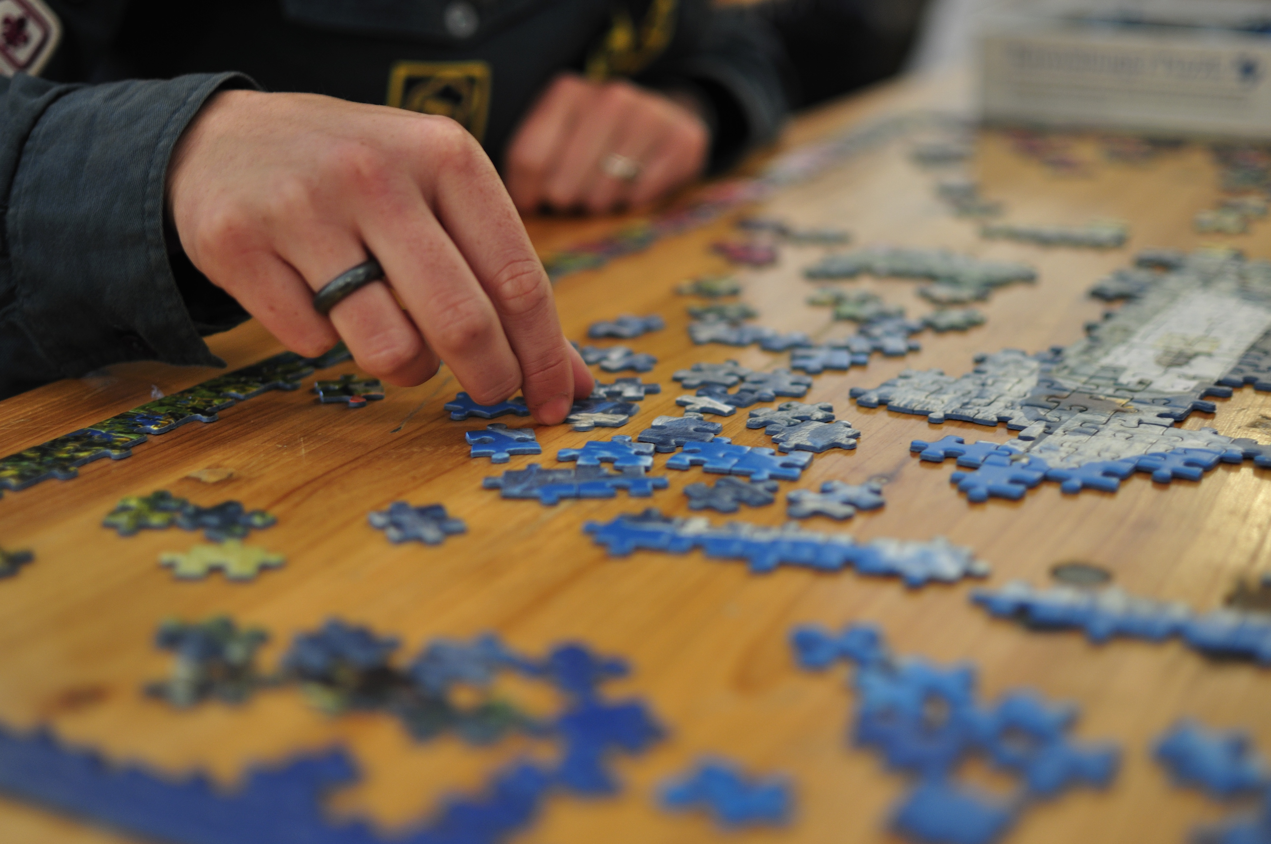 A completed jigsaw puzzle with a missing piece being placed into the puzzle